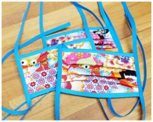 Starke Menschen nähen Behelfs-Mundmasken